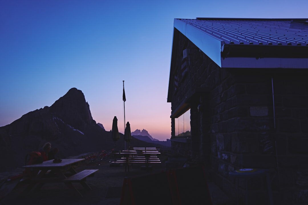Luxury Swiss alpine chalet exterior at dusk with warm lighting